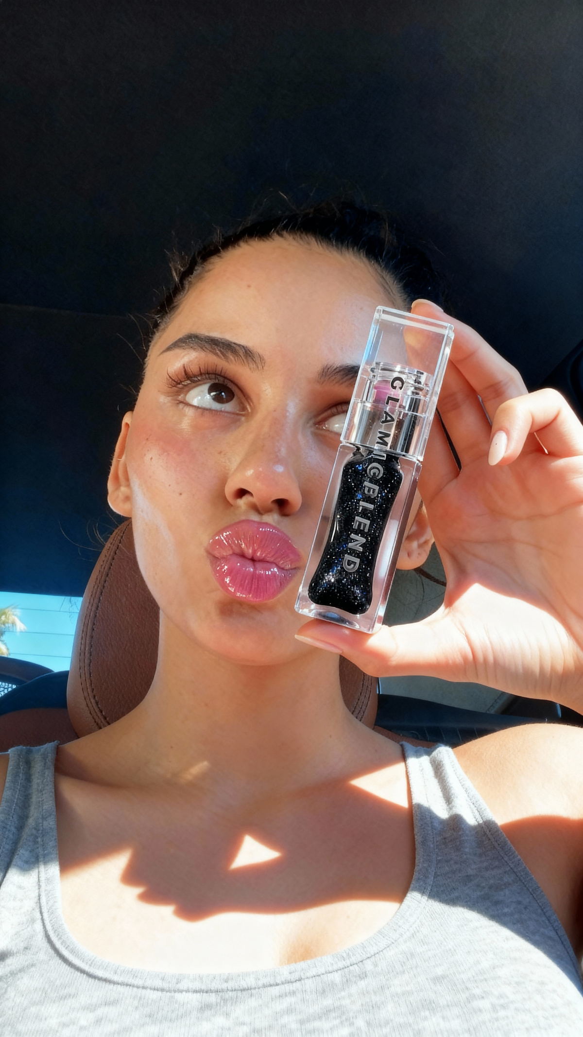 Selfie d’une cliente tenant l’huile à lèvres Exotic Extreme Noir