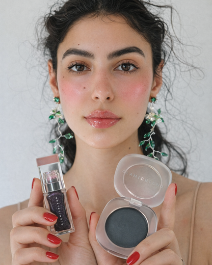 Modella che tiene l'olio labbra Exotic Extreme Noir ed Exotic Galaxy Blush